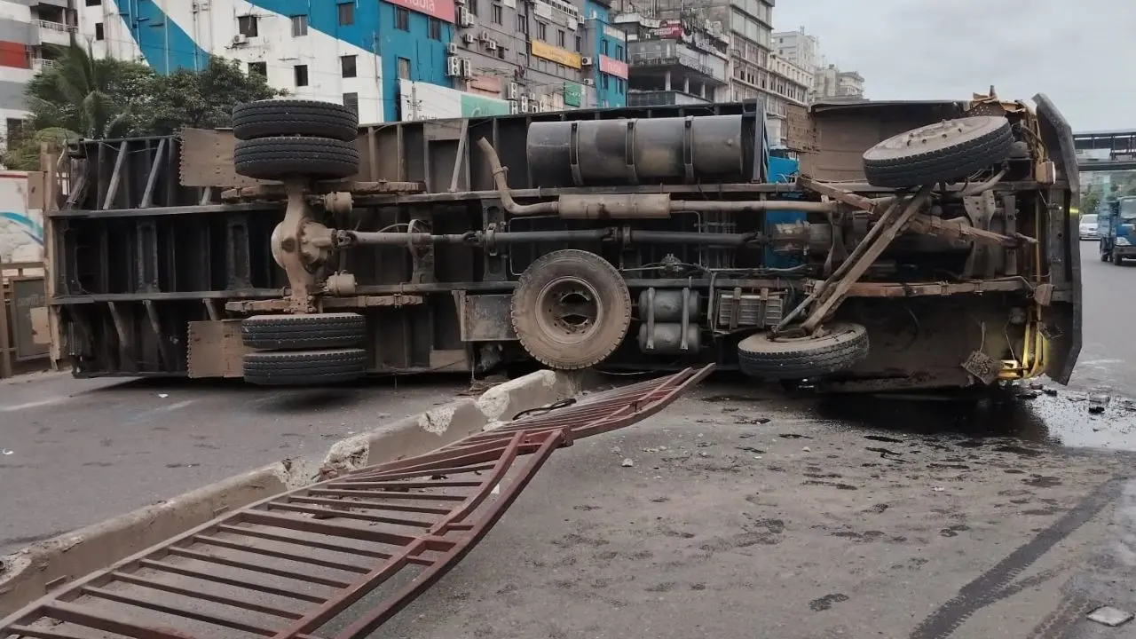 উত্তরায় মধ্যরাতে উল্টেছে কাভার্ড ভ্যান, সরানো যায়নি দুপুরেও।